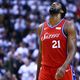 Pictured: Philadelphia’s Joel Embiid cranes his neck to look up at a 6-foot pull-up bar, just out of frame.